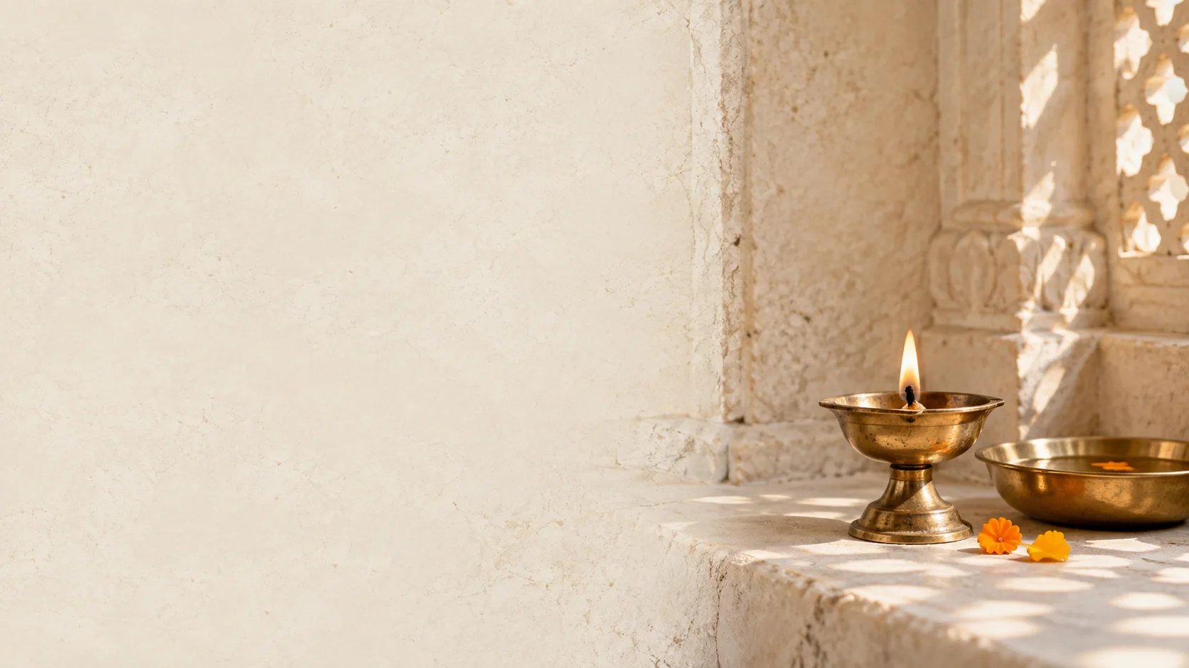 A brass diya in a sunlit stone temple alcove